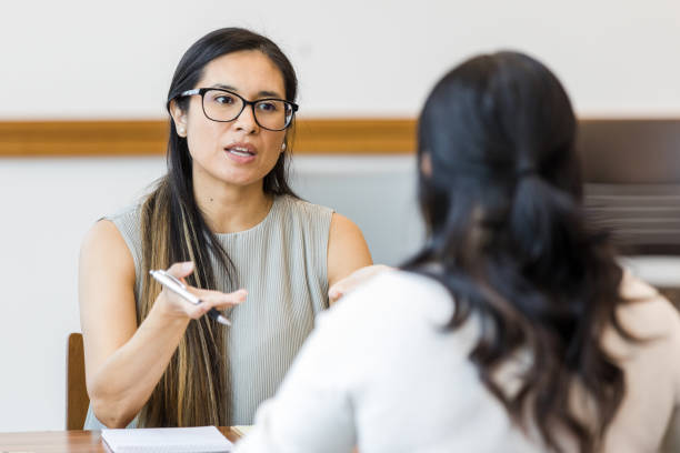 mental health therapist meets with her client in the conference room - coach imagens e fotografias de stock