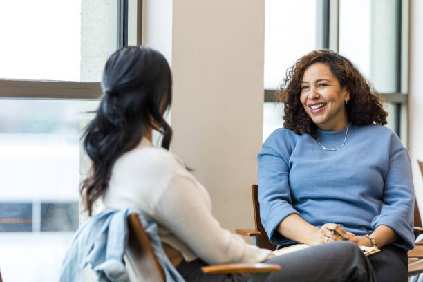 istock Female therapist smiles while she talks with her female client 1470588655