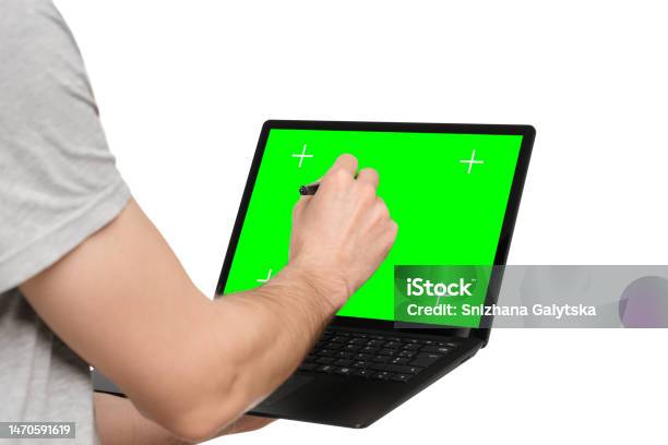 A Man In A Tshirt Holds A Laptop An Ultrabook And Puts An Electronic Signature With His Other Hand Stock Photo - Download Image Now