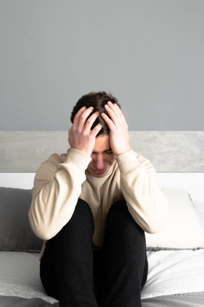 istock Sad young man laments sitting his bed 1470594154
