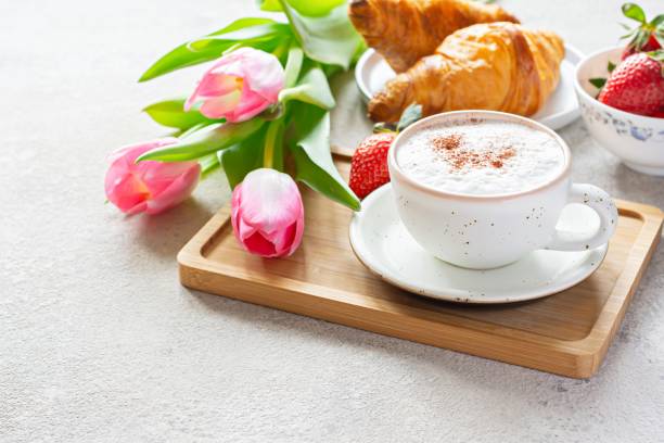 feliz día de la madre, hermoso desayuno, almuerzo con taza de café (capuchino) croissants frescos, fresas en bandeja, ramo de tulipanes como regalo. - brunch fotografías e imágenes de stock
