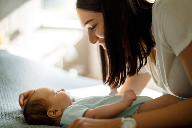 istock Happy mother playing with her newborn baby 1470597710