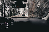 Dashboard view of a moving car and winter mountain. road. driving car in bad weather conditions.