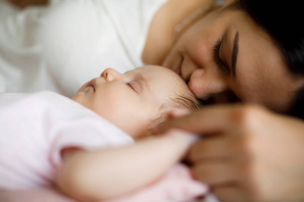 istock Mother and baby sleeping together at home 1470597957