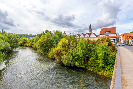 The Jagst River as it runs alongside the fortified medieval town of Möckmühl, in the district of Heilbronn, Baden-Württemberg, Germany