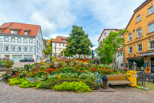 The Mockmuhl Town Square or Market Square Marktplatz with a colorful garden area surrounded by shops and cafes in the rural hill town of Mockmuhl, in the district of Heilbronn, Baden-Württemberg, Germany.
