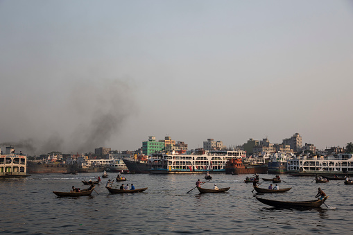 Traditional boats in Dhaka's busy harbour function alongside industry