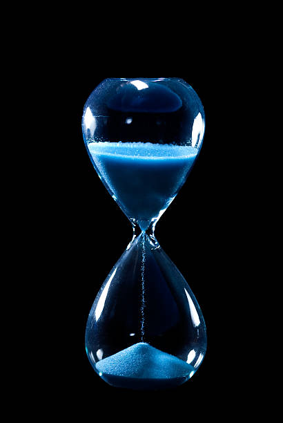 istock Blue hourglass with sand running through on black background 147060432
