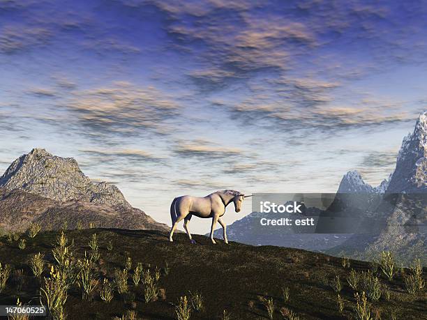 Lone Unicorn In A Field With Mountains In The Background Stock Photo - Download Image Now