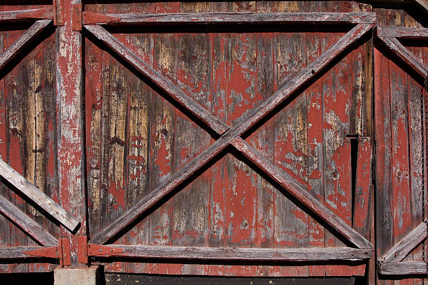 istock Old Barn Door with Fading Red Paint 147060749