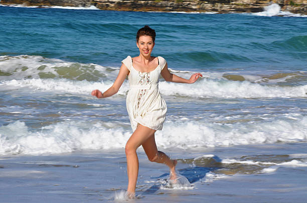 Beautiful young girl runs in the water on Bondi Beach stock photo