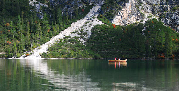 istock Couple in row boat on a green mountain lake 147061277