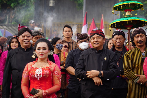 Blitar, East Java, Indonesia - June 26th, 2022 : Indonesian with javanese traditional cloth on tumpeng agung umpak bale kambang carnival. It is hinduism traditional ceremony