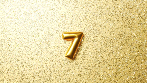 istock 3D Illustration.Three-dimensional numeral 7 on a glittery gold background; golden balloons; balloon numbers. 1470616549