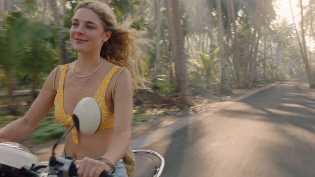 travel woman riding motorcycle on tropical island road trip enjoying motorbike ride happy independent woman exploring freedom on vacation
