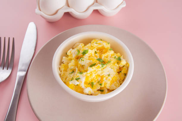 istock Scrambled eggs on bowl, delicious meal, pink background 1470622370