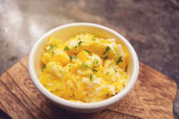 istock Scrambled eggs on bowl, wooden table, close up view 1470624979