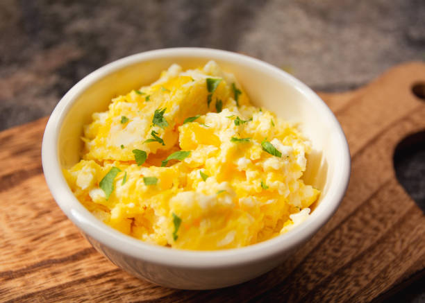 istock Scrambled eggs on bowl, wooden table, close up view 1470624982