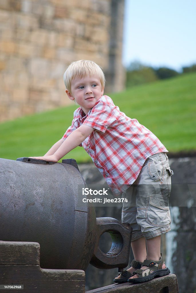 Bambini che giocano su cannone al Castello di Alnwick, Northumberland - Foto stock royalty-free di Alnwick