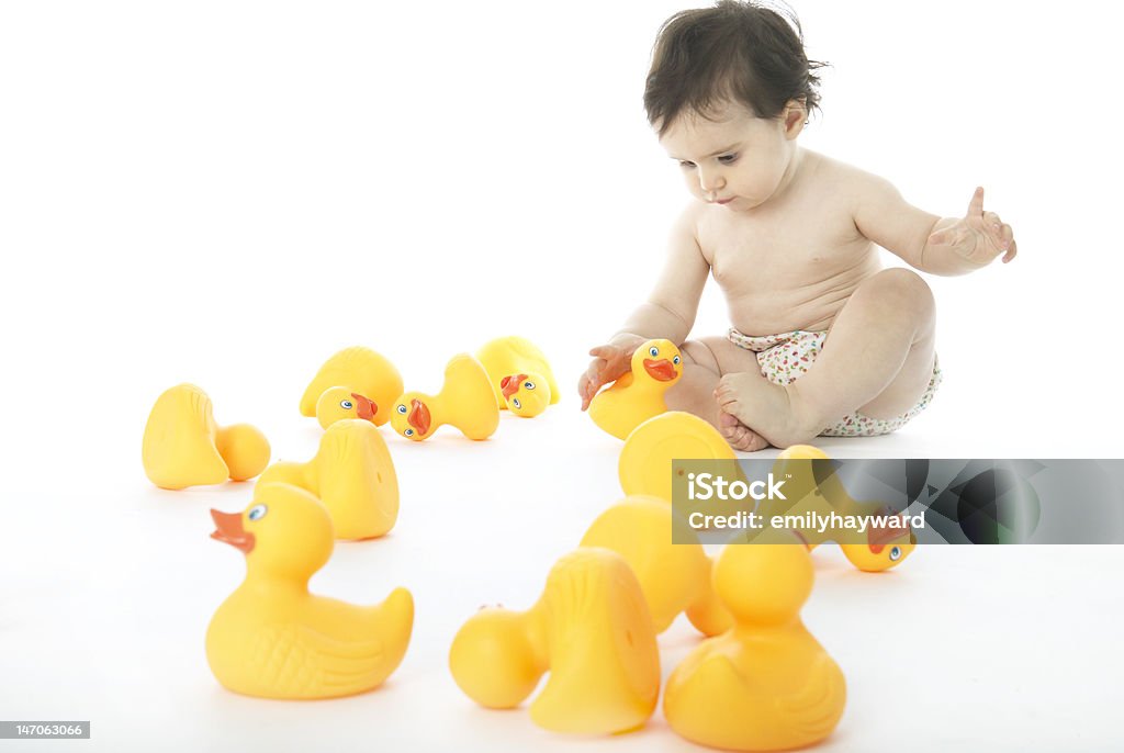 Baby With Rubber Ducks Baby Girl in a diaper With Rubber ducks. On white background 12-17 Months Stock Photo