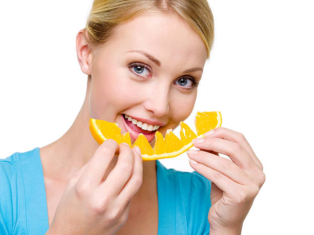 istock smiling woman eats the fresh orange 147063546
