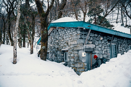 Mid adult male unlocking a vacation rental in the snowy mountains in rural Japan