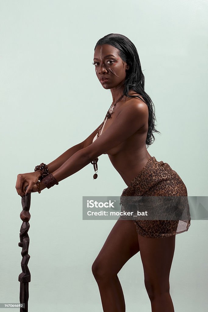 Ethnic Afro American woman with walking stick Dark skinned indigenous African American female standing, holding wearing original tribal themed face-paint and necklace with chief stuff 20-24 Years Stock Photo