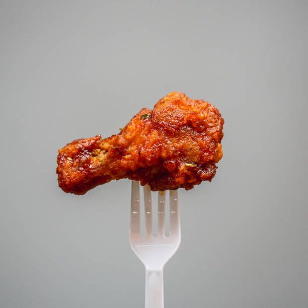 istock fried chicken on plastic fork with grey background, fast food Concept with copy space. 1470648833
