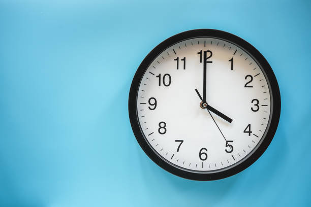 istock Classic black and white analog clock on blue background at Four o'clock with copy space 1470648842