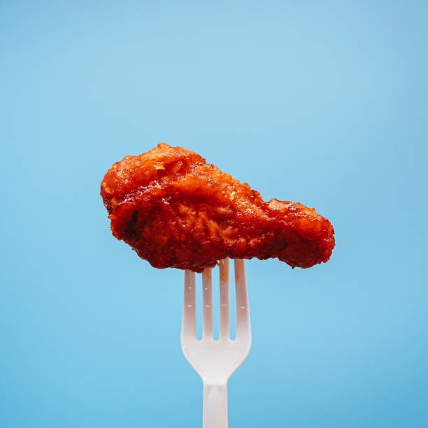 istock Korean style fried chicken on plastic fork with blue background, fast food Concept. 1470648891