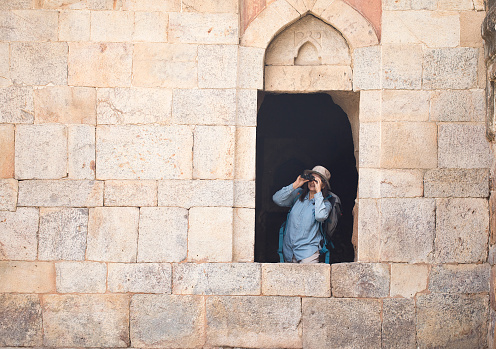 Senior woman exploring ancient history using binoculars