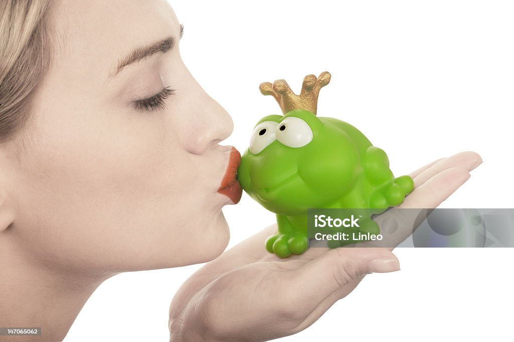 Frog prince being kissed by a beautiful glamour model Frog prince being kissed by a beautiful glamour model with pale skin isolated on white Frog Stock Photo