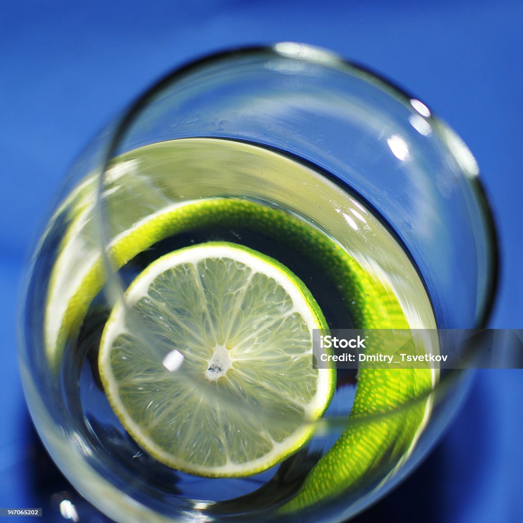 fresh drink A glass of cocktail with lime isolated on a blue background Alcohol - Drink Stock Photo