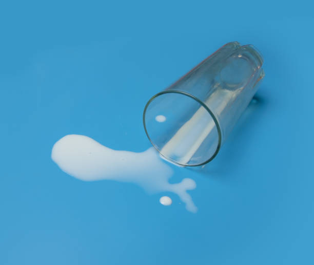 istock Milk spilled from glass on a blue background. 1470654505