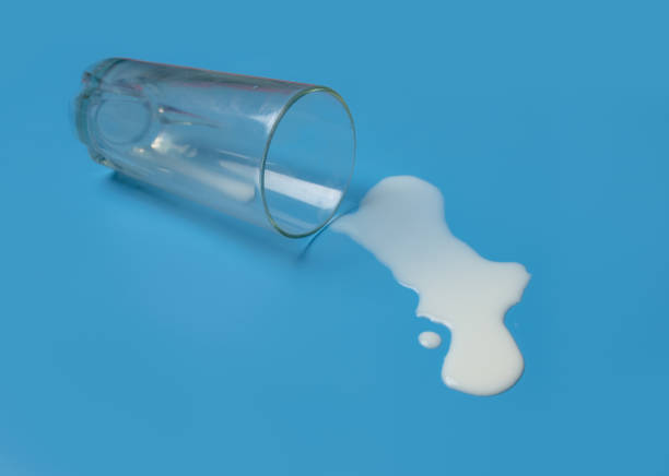 istock Milk spilled from glass on a blue background. 1470654510