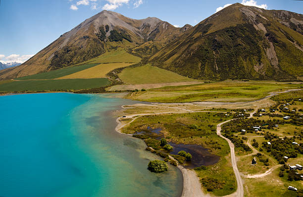 Lake Coleridge is in the South Island of New Zealand and is famed for its bright turquoise colour. The colour is natural and is caused by fine rock particles washed down from glaciers higher in the mountains, The bands of colour in the lake are caused by the differing depths of the water and weeds. This was taken from a helicopter and some minor motion blur and reflections on the helicopter window are visable at 100%.