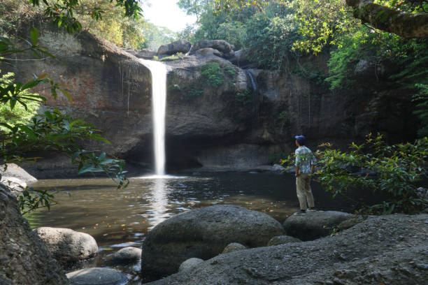 istock asian men standing on the rock with water fall background. 1470654882