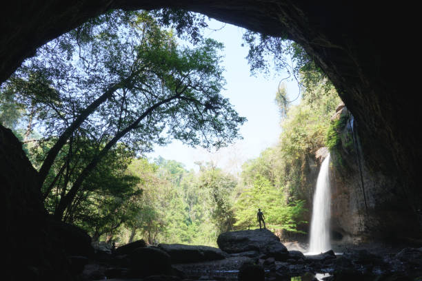 istock asian men standing on the rock with water fall background. 1470654900