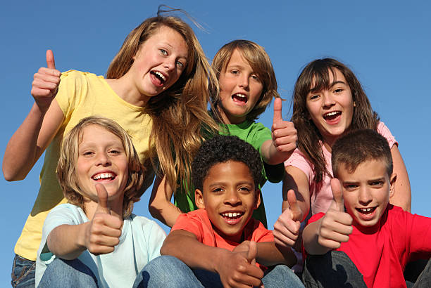 grupo de niños de diversas retención pulgar hacia arriba - youth organization fotografías e imágenes de stock