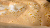 Appetizing background showing a close-up of a browned meringue with precipitated droplets of melted sugar. Top view of homemade cheesecake with dew. copy space.
