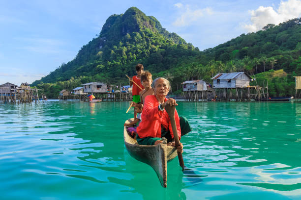 Sea Gypsy Semporna Sabah, Malaysia - Dec 03, 2018: Sea gypsy or bajau laut people paddling a boat in the Celebes sea in Sabah Borneo Malaysia. mabul island stock pictures, royalty-free photos & images