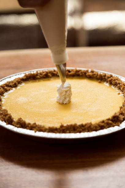 istock Woman preparing a cheesecake. She is putting cream on it to give it the final touch. 1470657117