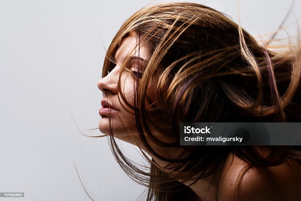 Face of beautiful young woman with hair flying Face of beautiful young woman with hair flying in wind Exploding Stock Photo