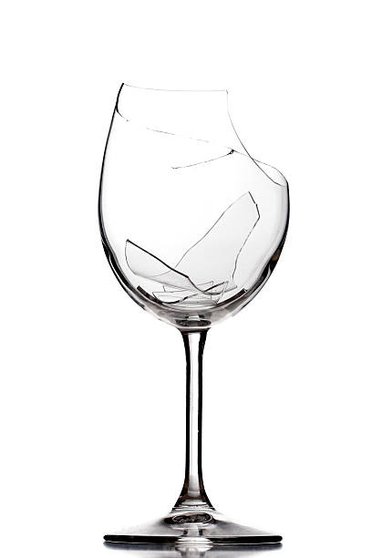 Broken wine glass shattered into pieces stock photo