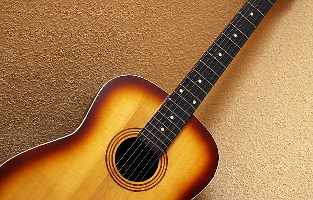 istock Acoustic Guitar Isolated On Wall 147065878