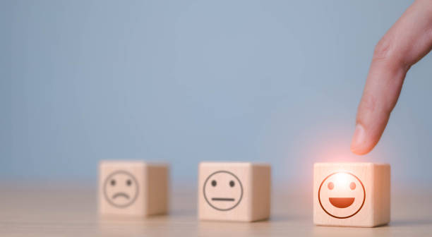 istock Users choose the highest satisfaction. Businessman's hand selects a smiley face on a wooden block. 5 star satisfaction. Excellent business rating experience. Satisfaction survey concept. 1470658964