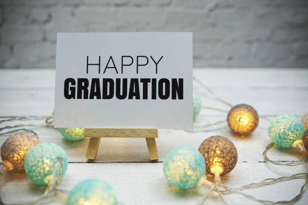 istock Happy Graduation text on white brick wall and wooden background 1470660902