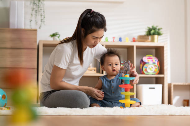 istock Asian mom teaching baby boy learning and playing toys for development skill at home or nursery room. Happiness mother and baby spending time together at warmth place. Good moment with mom and baby 1470662495