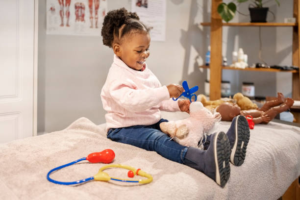 istock Cute little surgeon doing surgery on her soft toy at home 1470665278