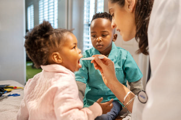 istock Boy watching his mother taking his sister's temperature in her doctor's office 1470665365